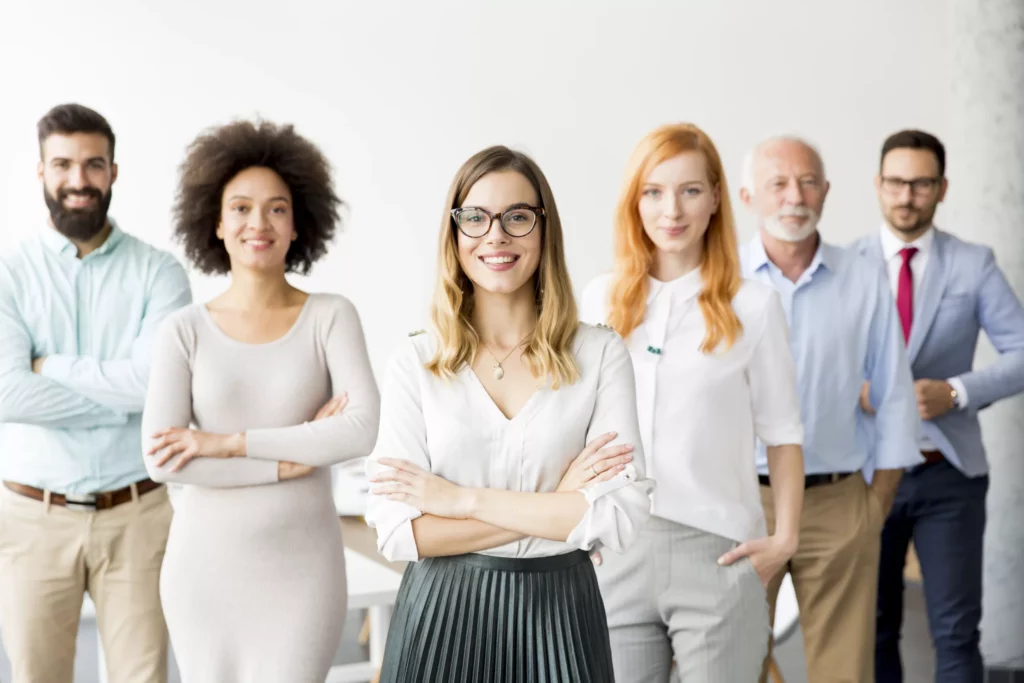 Un groupe de personnes debout et habillées pour travailler dans un bureau