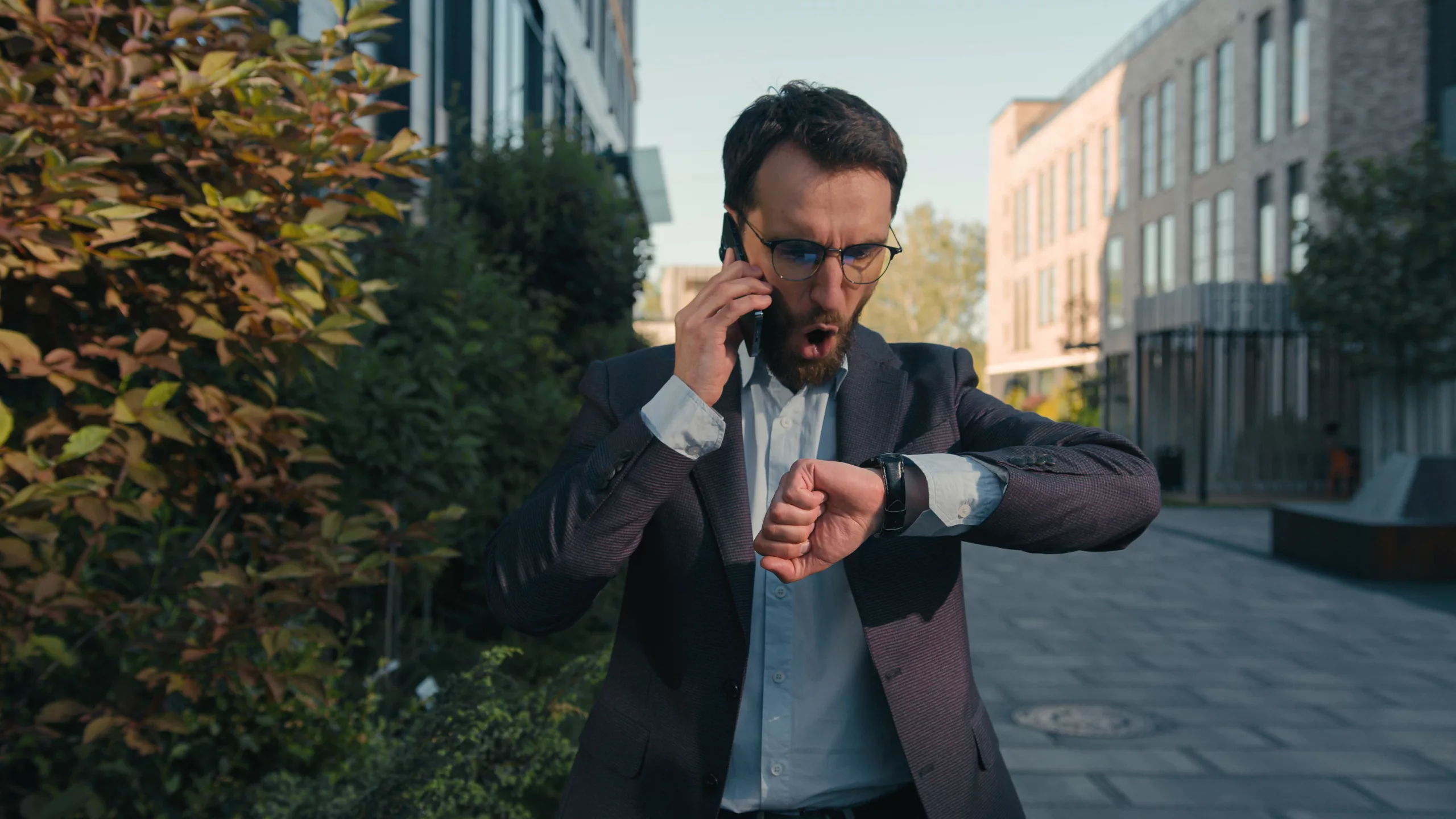 Homme en costume au téléphone et n'arrive pas à dire l'heure en anglais