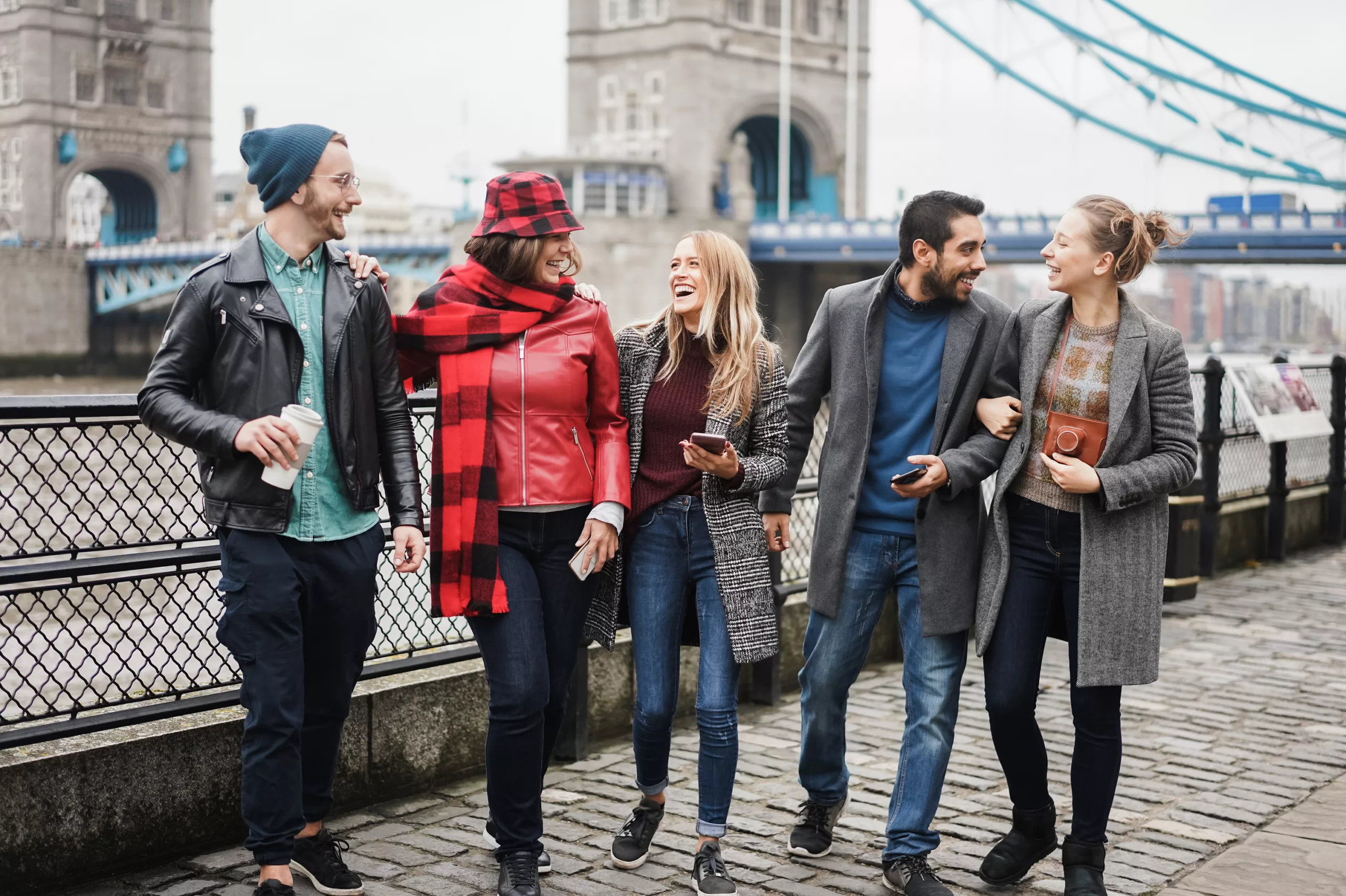 Jeunes amis rigolent ensemble devant le tower bridge à Londres.
